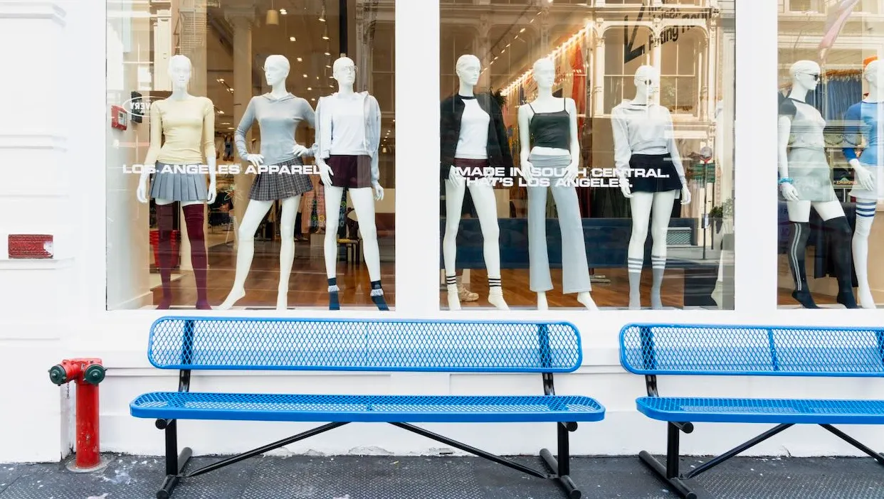 Blue benches in front of a clothing store.