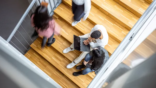 A busy staircase with several college students.