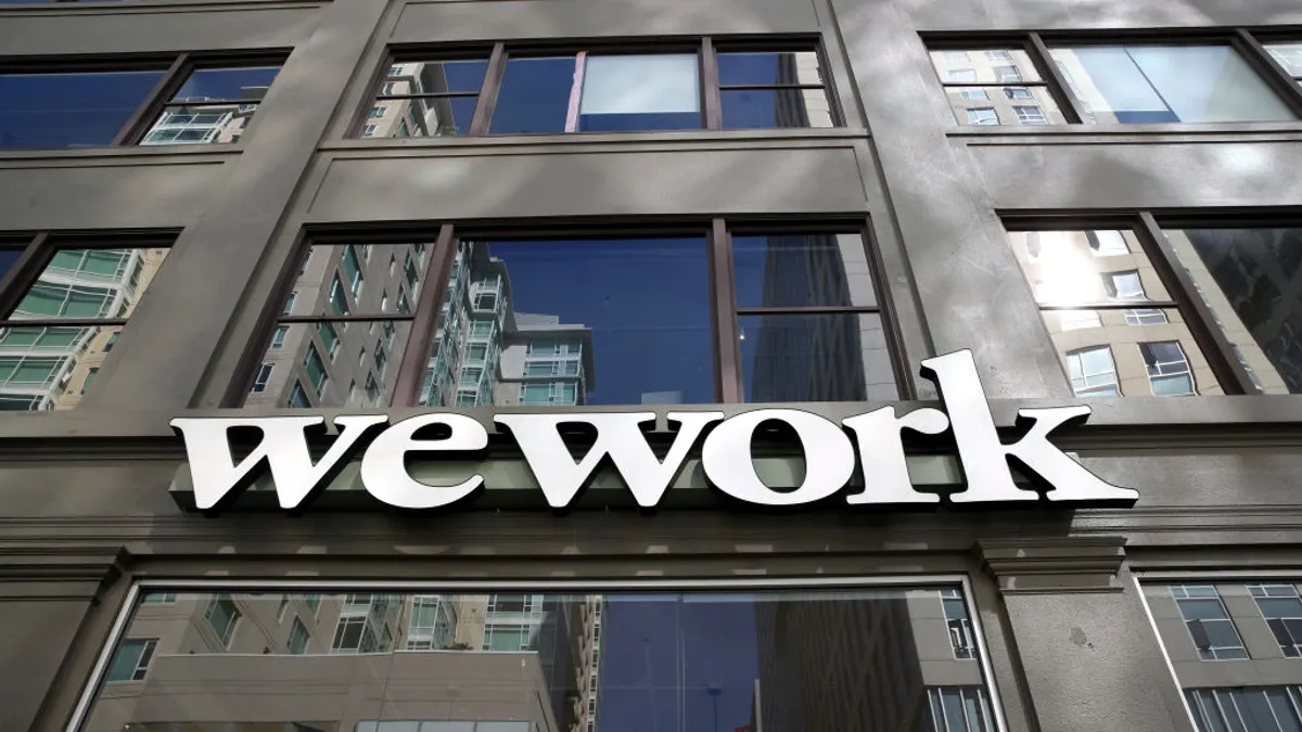 A sign is posted on the exterior of a WeWork office.