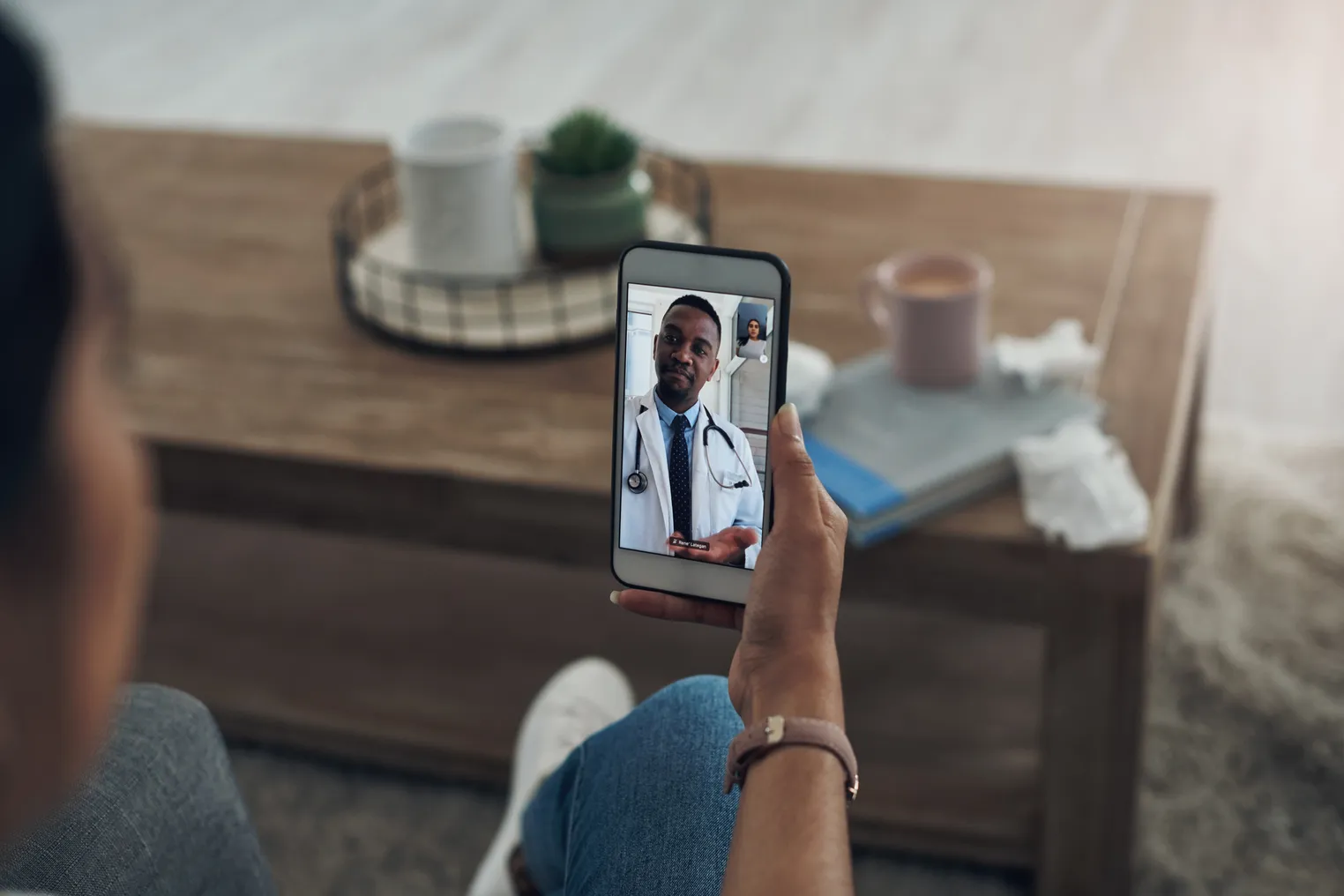 Shot of an unrecognizable person on a videocall with a doctor - stock photo