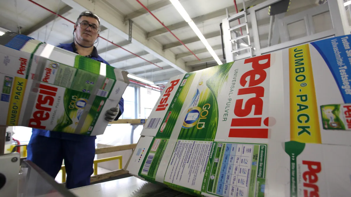 A worker carries folded Persil detergent packages at the manufacturing site of German toiletries, cosmetics and detergent maker Henkel plant.