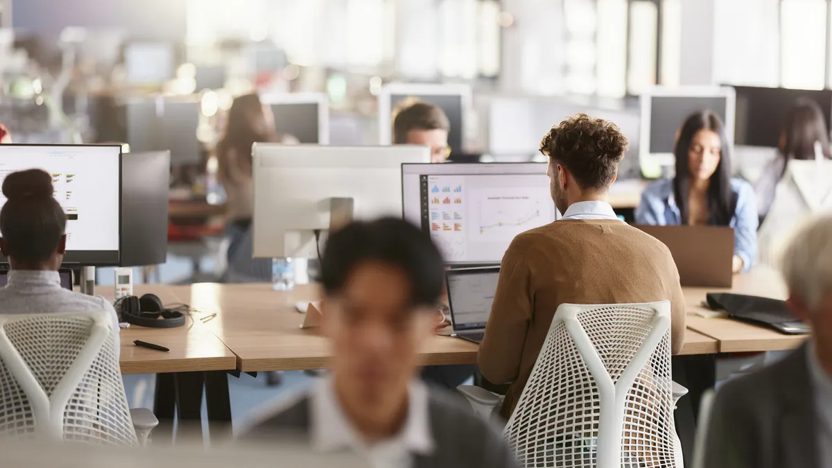 An overview of an office with a young professional in focus