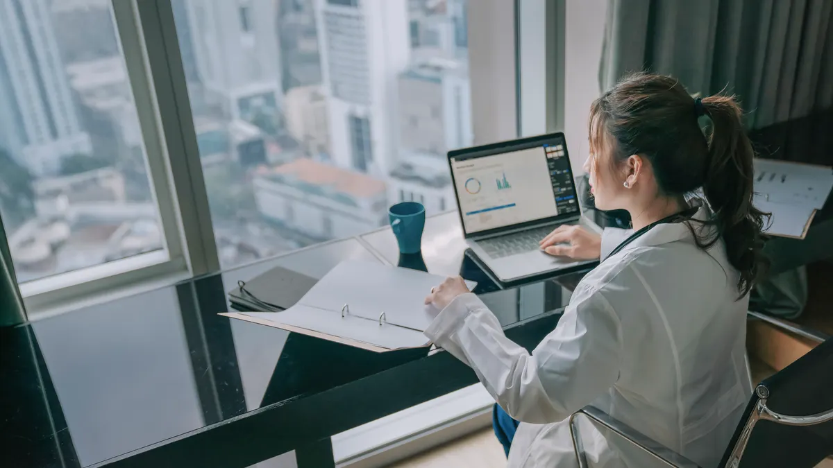 Female Doctor researching in laptop