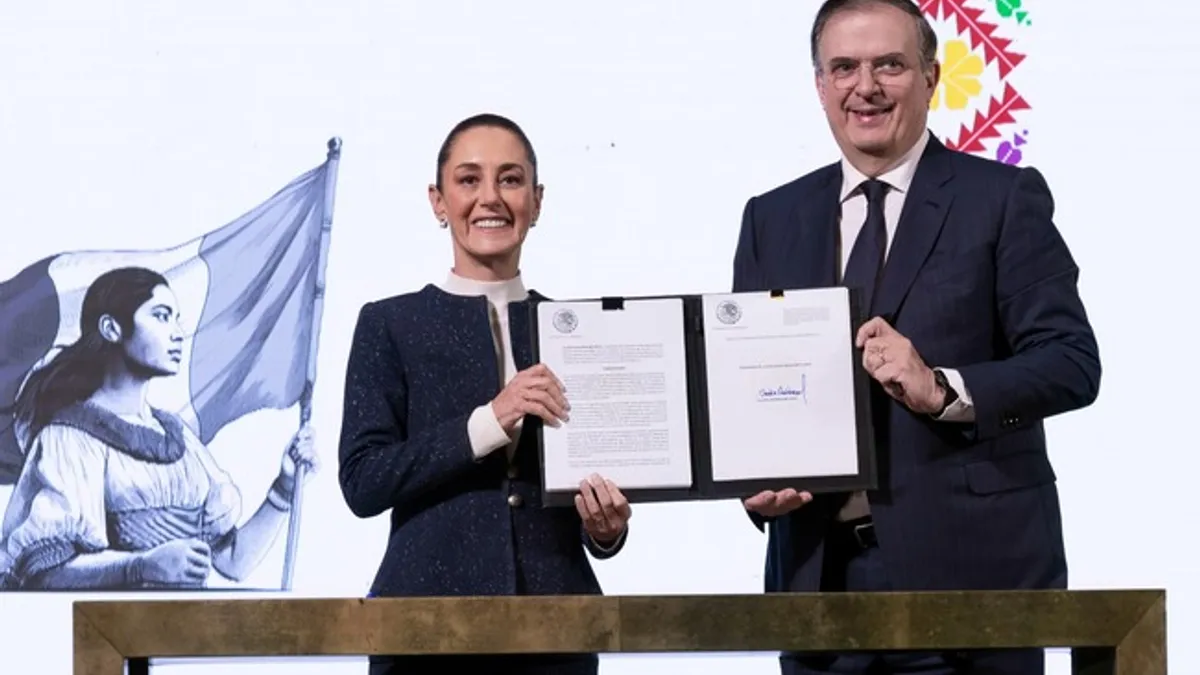 Mexico President Claudia Sheinbaum and Economy Secretary Marcelo Ebrard stand with a signed decree affecting apparel duties.