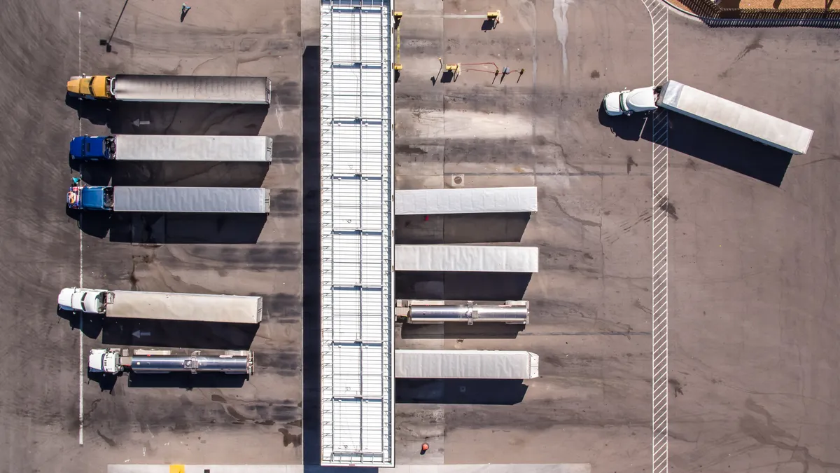 An overhead view shows the tops of trucks as they park, enter and leave a refueling stop in Texas.