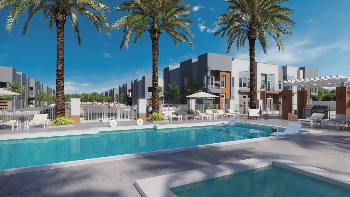 A pool area with palm trees in front of an apartment building.