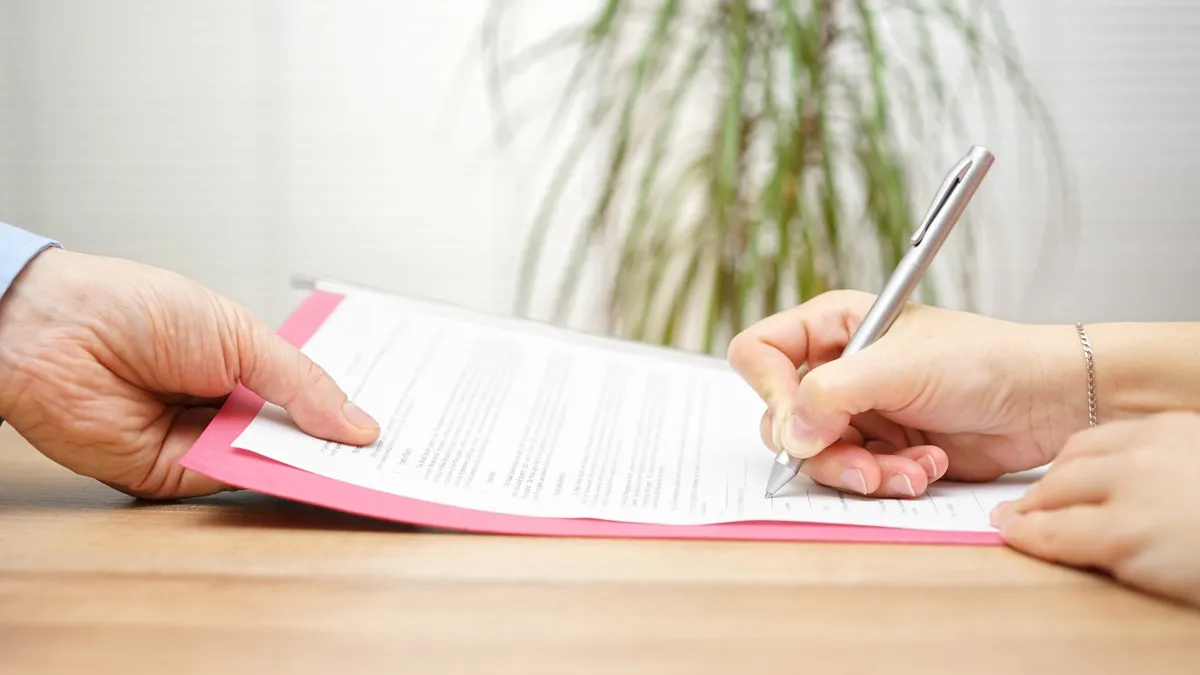 An employee signs their employment agreement