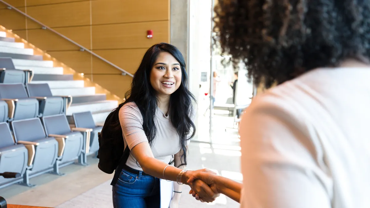 A person shakes another person's hand.