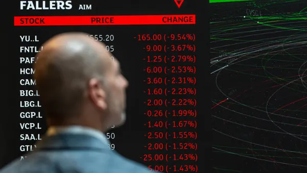 A member of staff poses next to a trading board at the London Stock Exchange on April 25, 2025 in London, England.