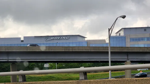 A building in the background with the white Boeing sign and logo on the front.