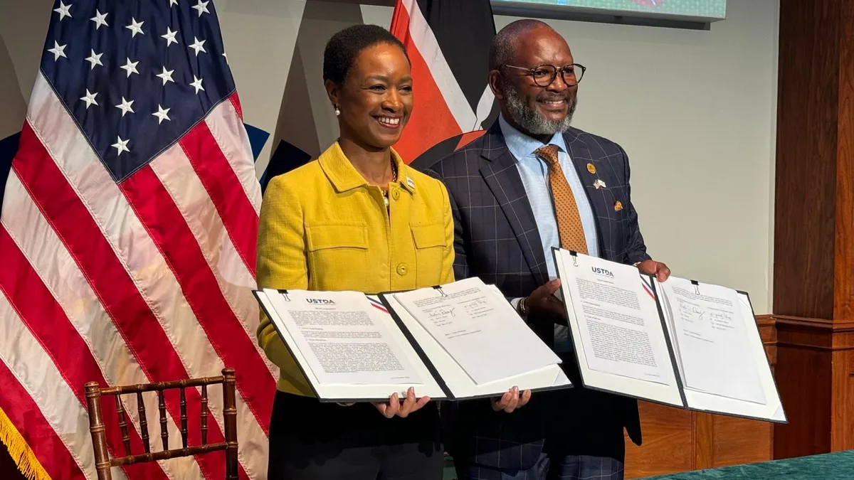 Two people holding up a grant agreement between Kenya-based startup Semiconductor Technologies Limited and the U.S. Trade and Development Agency/