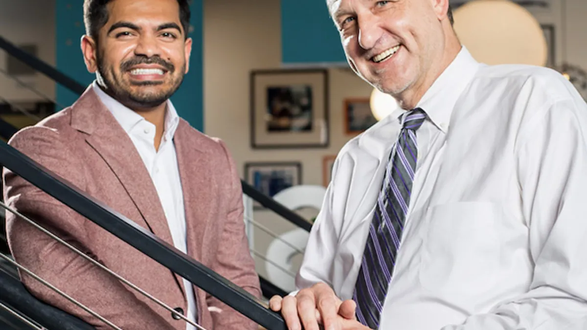 Two individuals, Mountain Express’ former co-CEOs, standing on a stairway for a portrait.