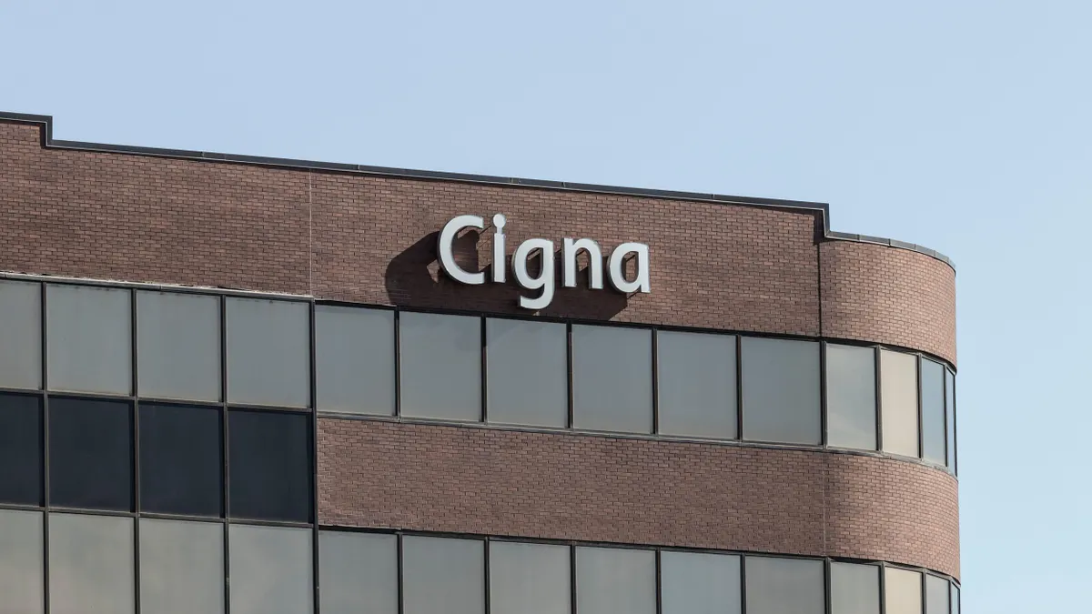 A commercial structure featuring a brick and glass façade displays a  Cigna logo at the top of the building.
