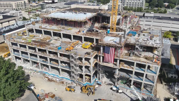 An aerial shot looking down at a building under construction with the wall ripped off.