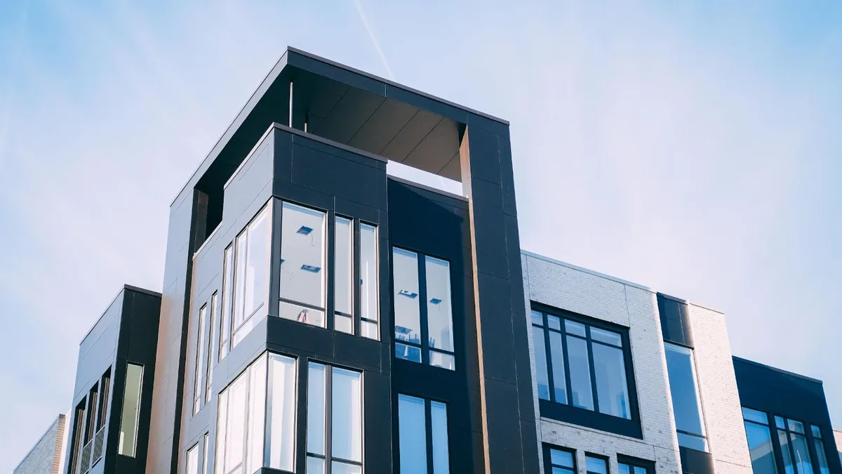 An apartment building with modern architecture against a blue sky.