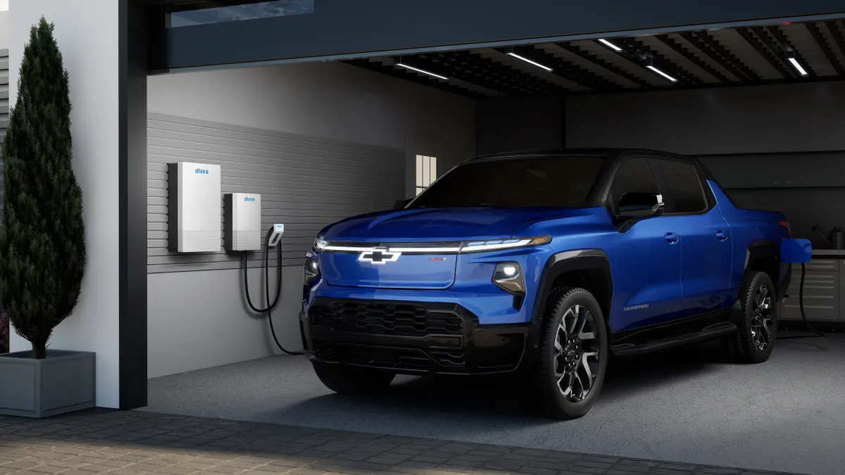 An electric pickup truck charging in a garage.