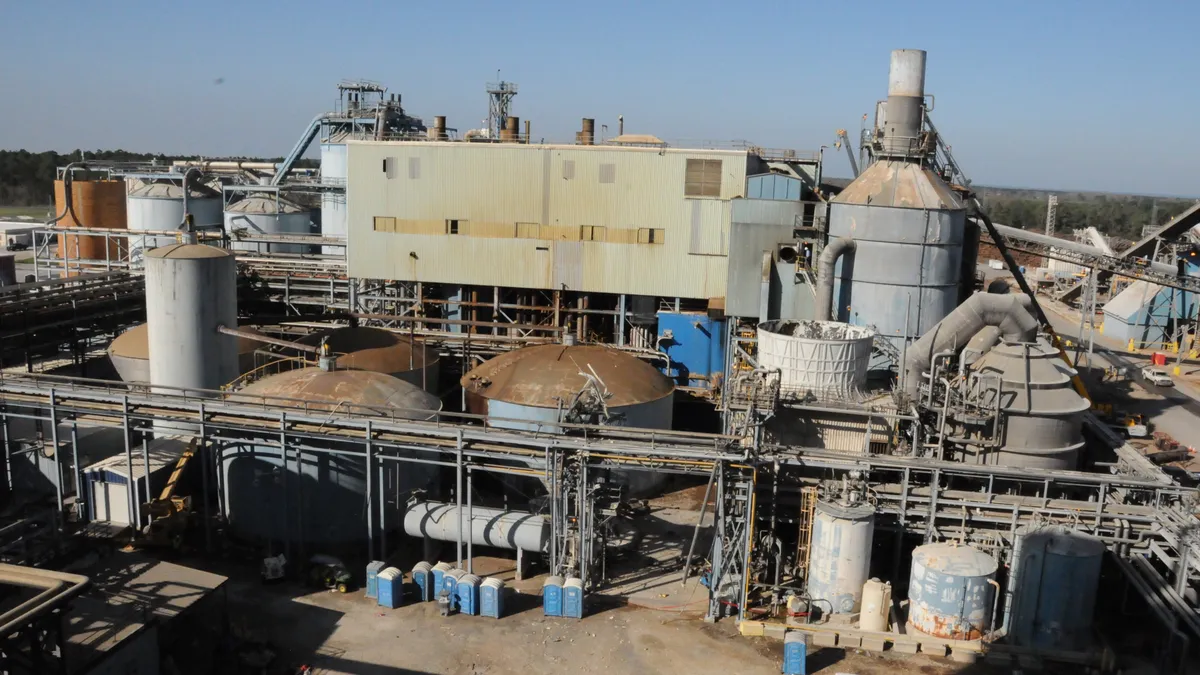 An exterior shot of an industrial facility with tanks and conveyors.