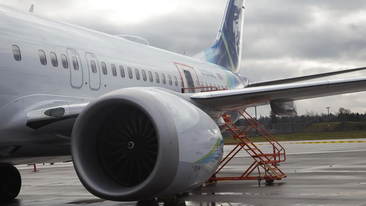 The left side of a Boeing 737 Max 9 grounded on a cloudy day.