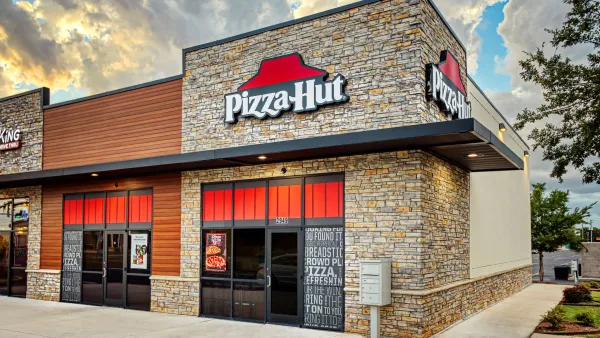 An exterior image of a Pizza Hut with bricks and red signage