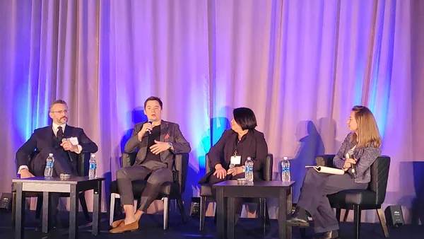 Four executives speaking during a conference