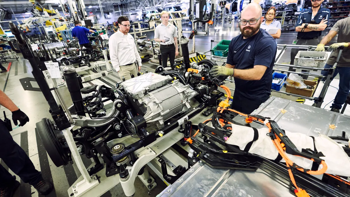 An auto worker at the Volkswagen assembly plant in Tennessee inspects components of the ID4 electric SUV.