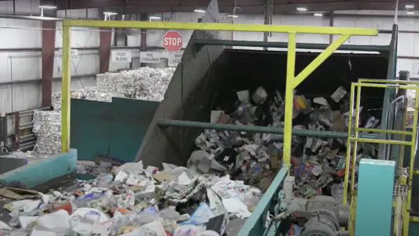 Collected packaging materials make their way along a conveyor belt in a materials recovery facility.