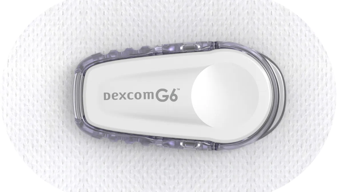 An oval shaped device on a patch says Dexcom G6.