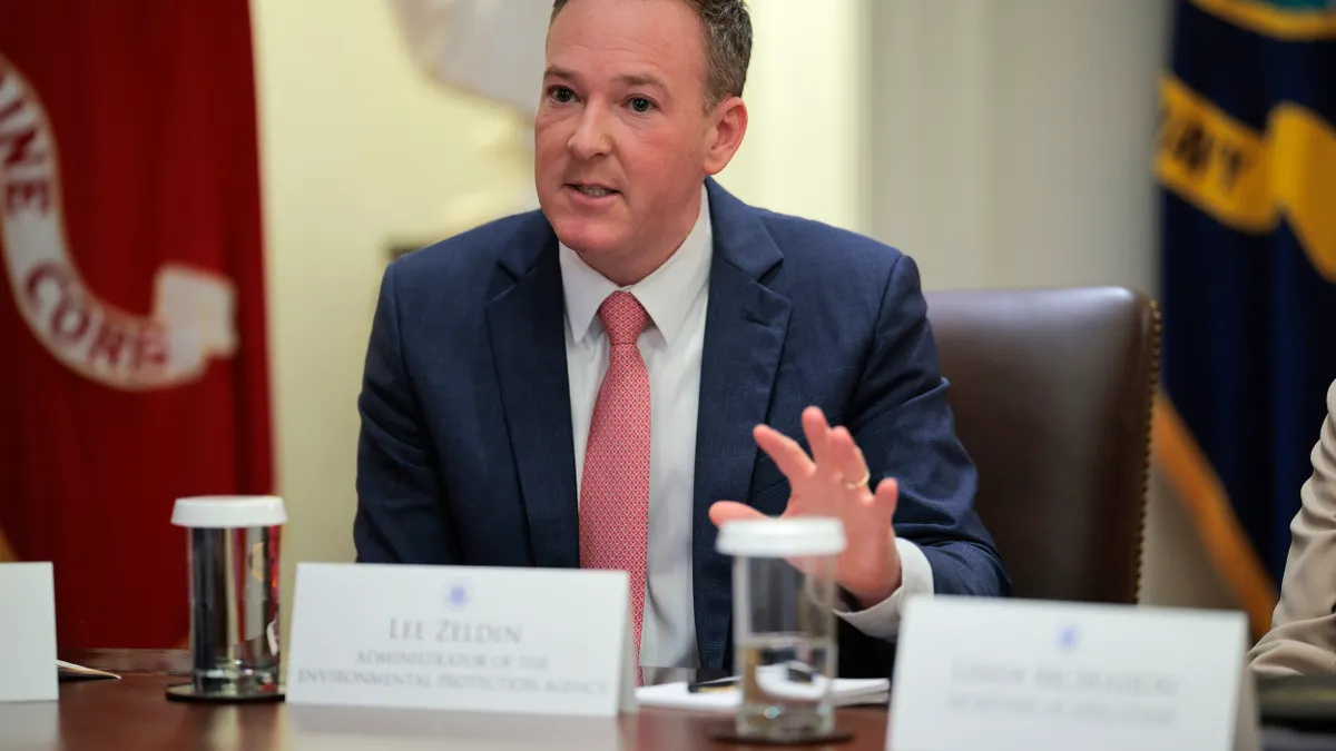 A person wearing a suit sits at a table.