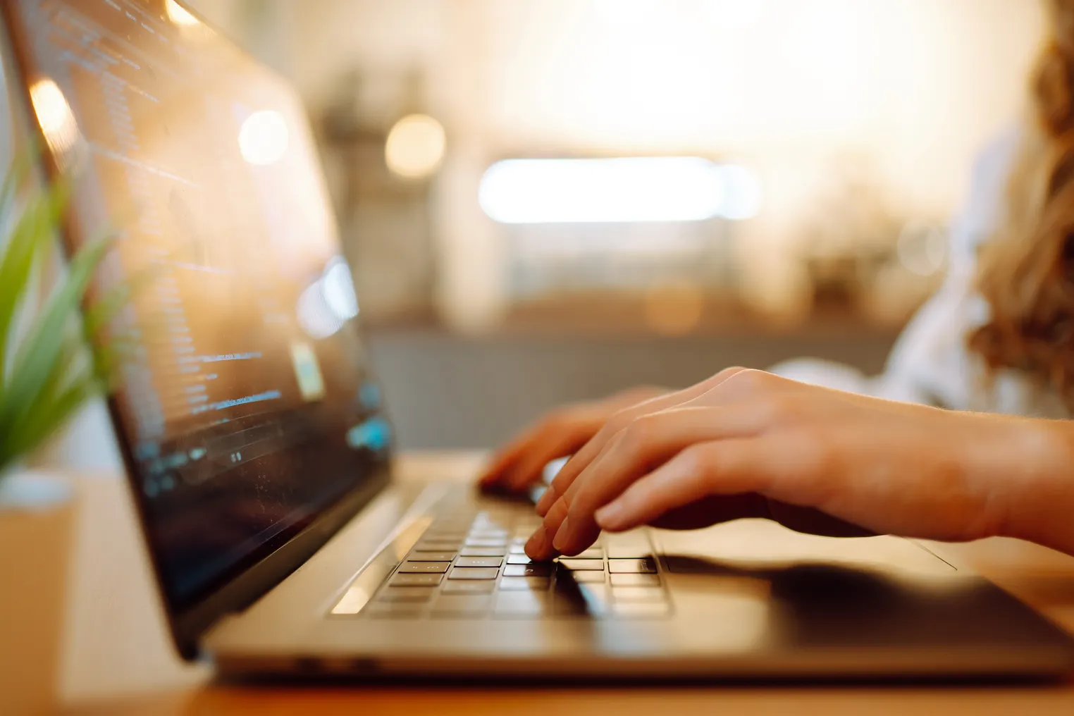 Hands type on a laptop keyboard.