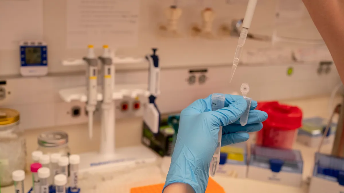 Gloved hands are seen measuring liquid with a pipette