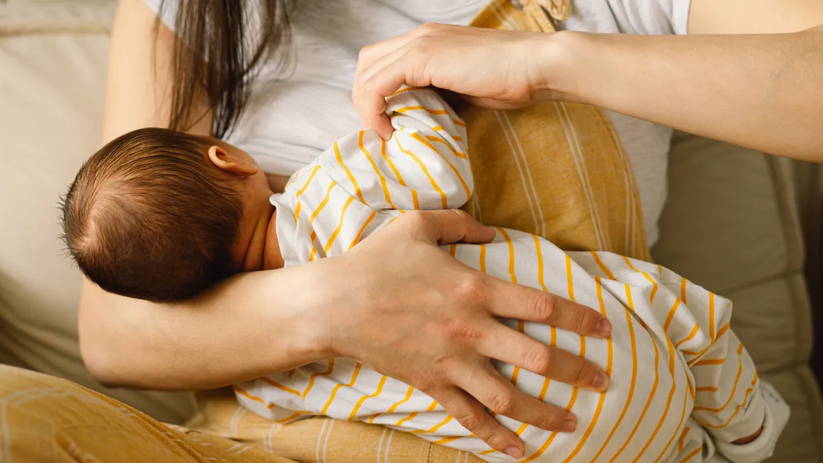 Portrait of parent and breastfeeding baby