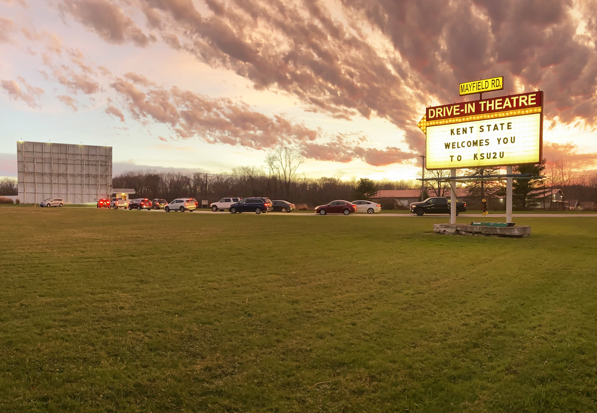 Cars enter a drive-in theatre for Kent State's admission's event