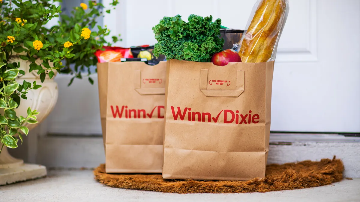 Brown paper bags of grocery products from Winn-Dixie sitting on a doorstep