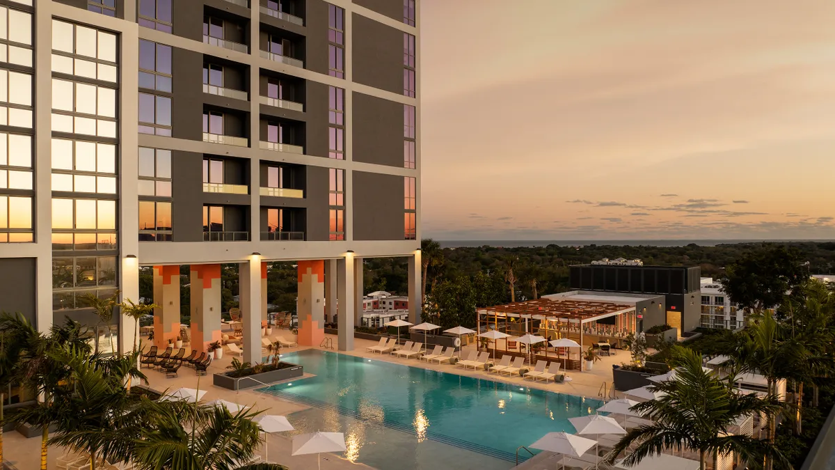 The pool deck of an apartment building at sunset.