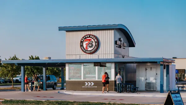 An image of a small restaurant with people gathered around. Thereis 7 Brew signage.