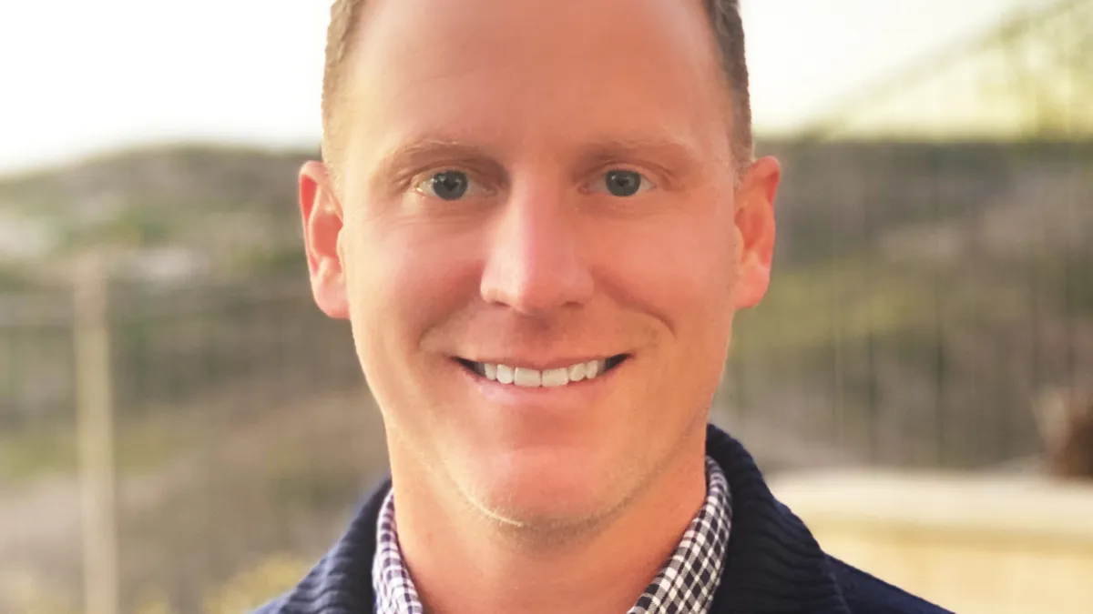 Headshot of man with wacky red hair and a smile