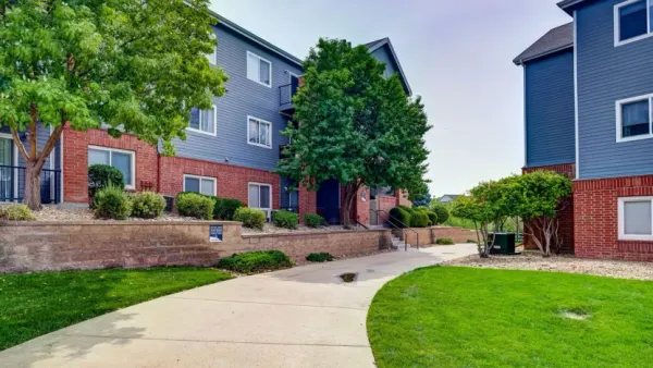 Paved walkway and grass between two apartment buildings