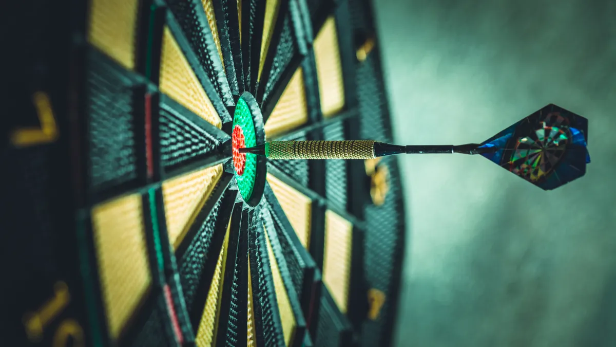 Image of a dartboard with dart hitting bullseye