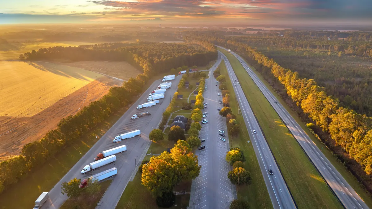 An aerial view of a rest area near an interstate, showing fields and sunshine.