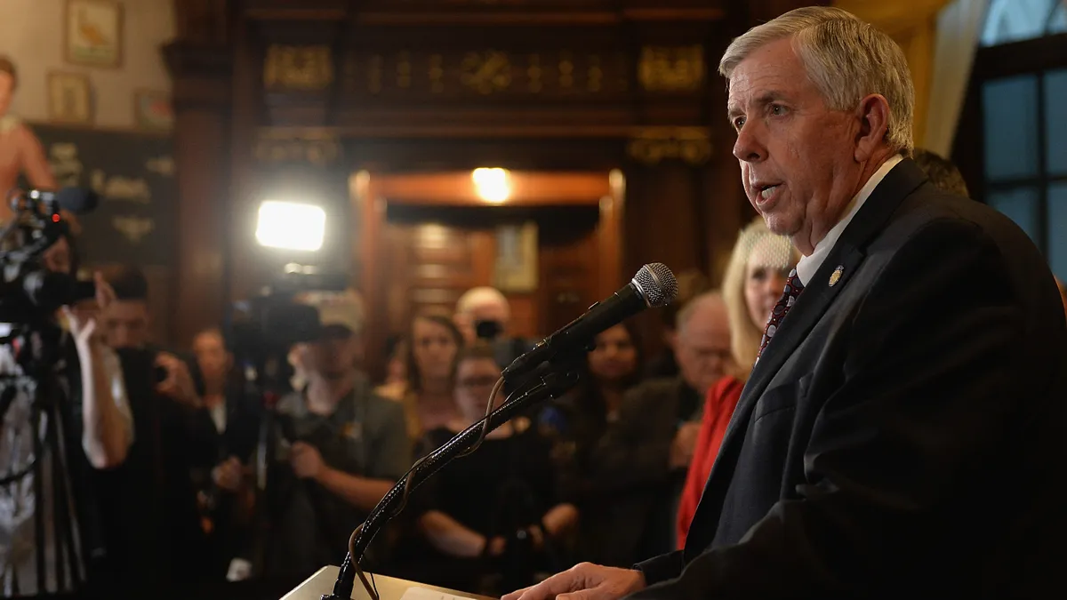 Man standing at podium in front of crowd