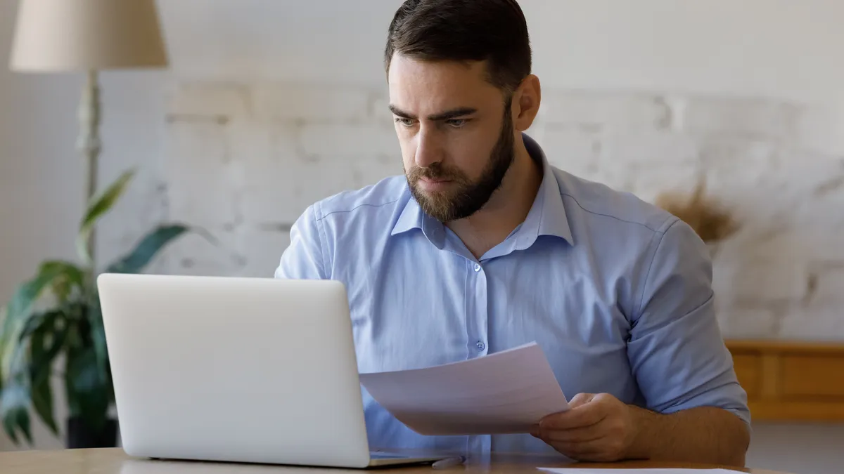 Focused millennial business man checking paper reports