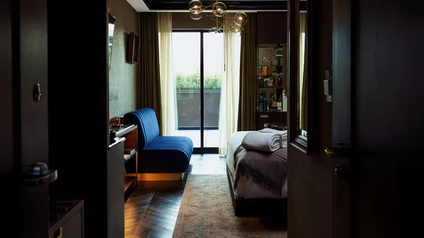 A room features a bed and a cabinet full of whisky bottles.