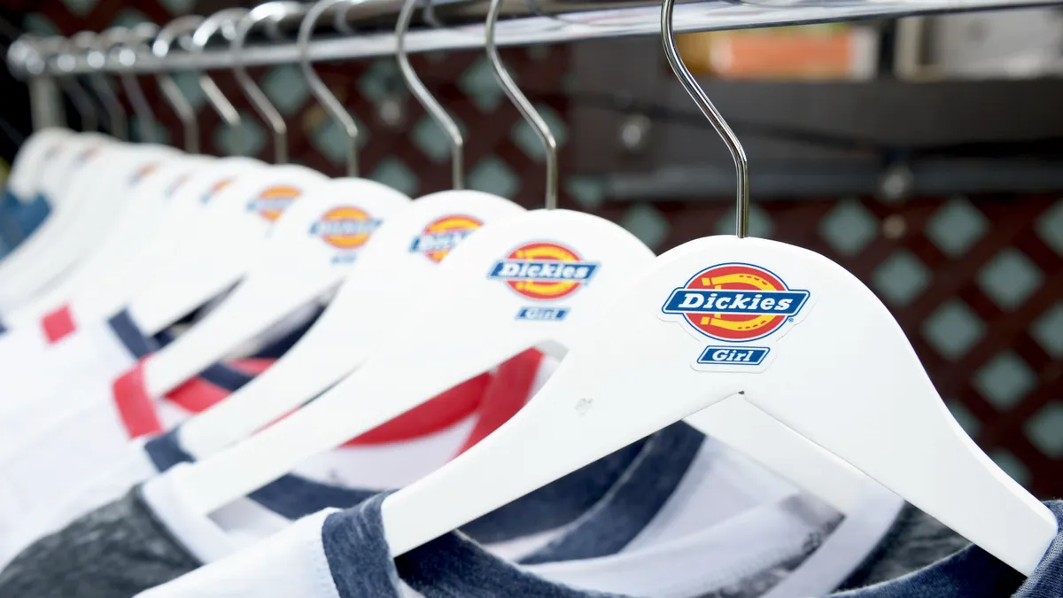 Hangers with the Dickies Girl logo hold t-shirts on a rack.