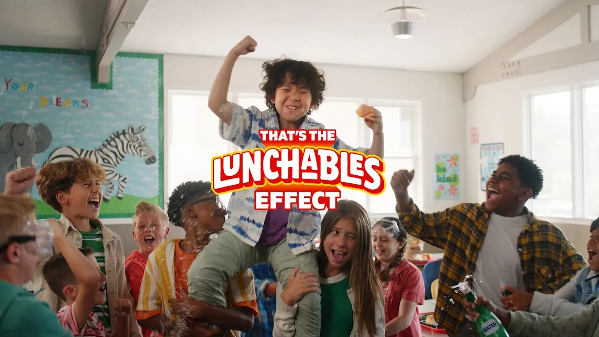 A kid is hoisted on the shoulders of his classmates.