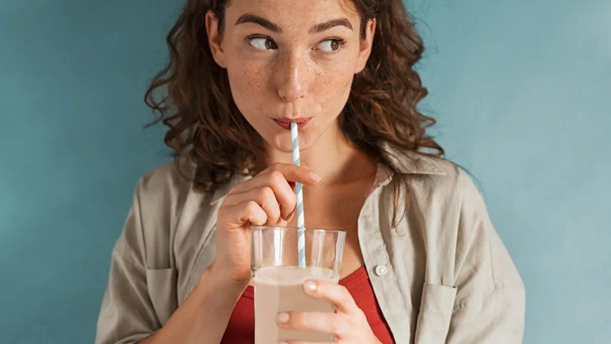 Woman sipping drink with straw.