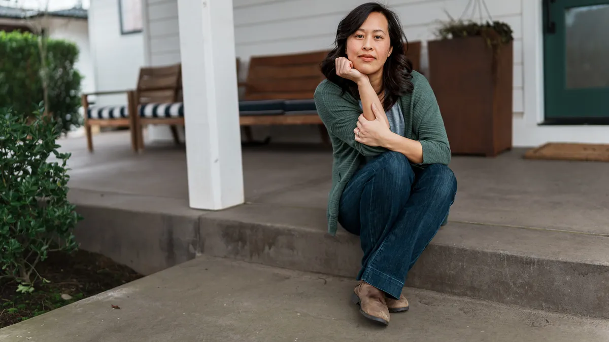 A Vietnamese person sits on front step of their home