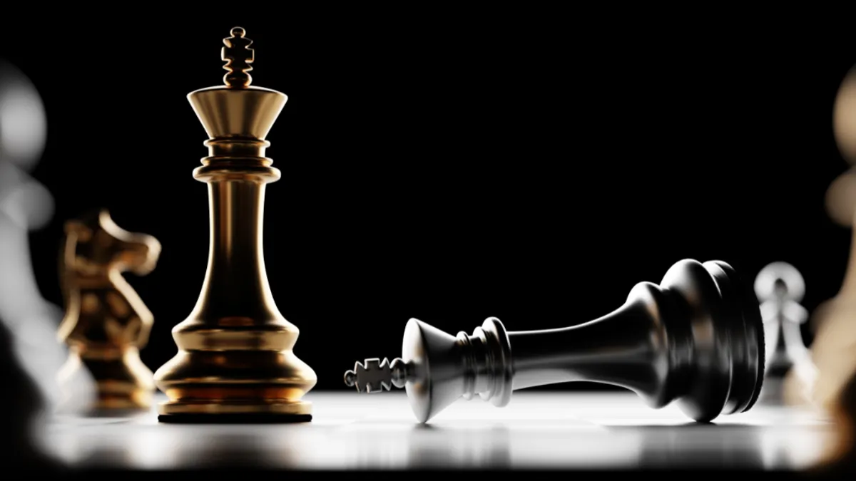 Two kings chess pieces focused on a chessboard and one king piece tipped over