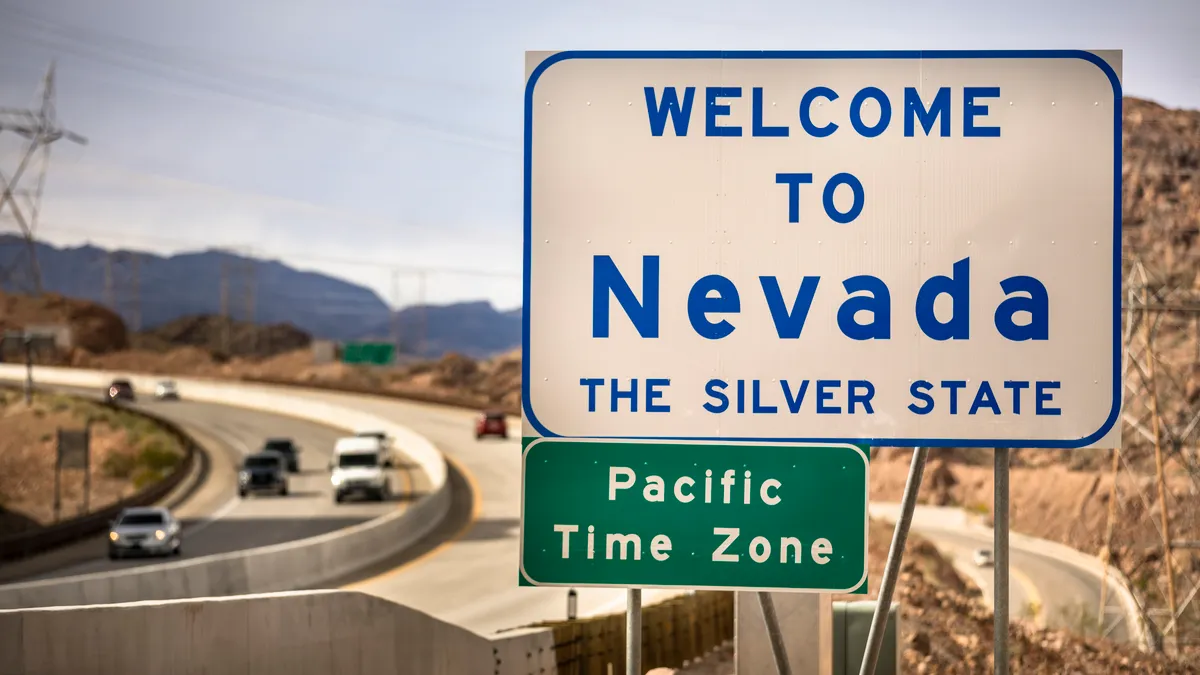 Entrance greeting sign on the highway border between Nevada and Arizona