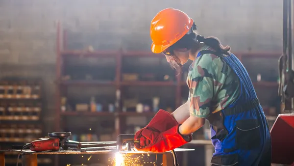 A worker uses welding tools.