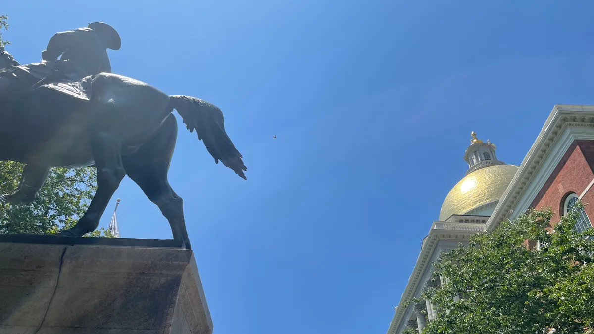 Statue of man on horse in front of gold-domed building